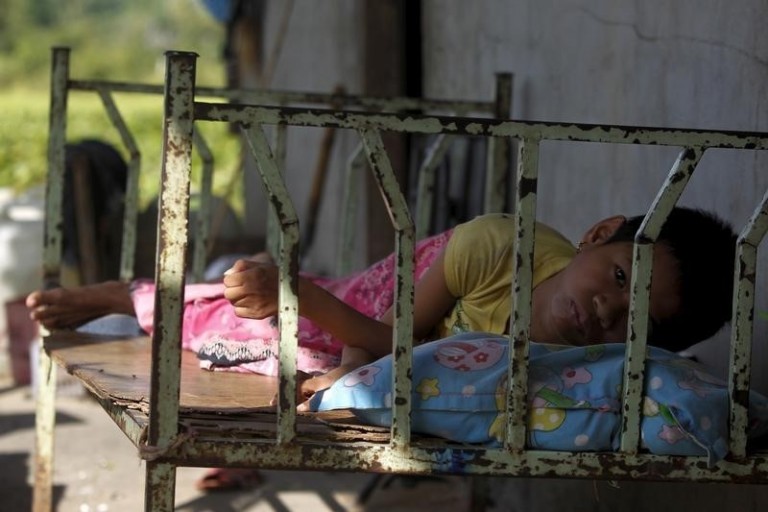 HIV patient Ma Sreymom rests in front of her home at Tuol Sambo village on the outskirts of Phnom Penh