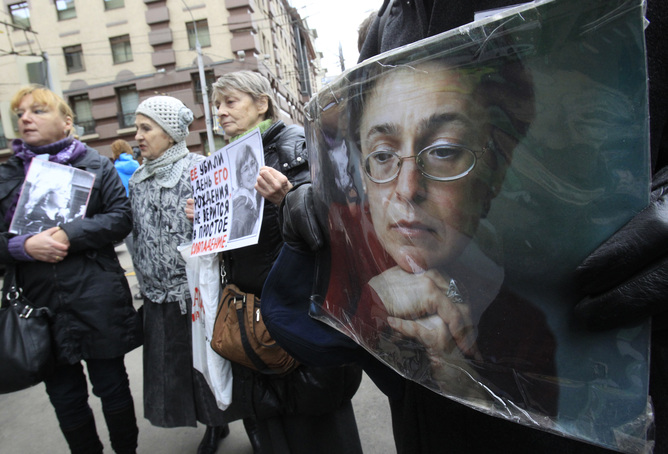 People hold portraits of slain journalist Politkovskaya on the sixth anniversary of her death, next to her block of flats in central Moscow
