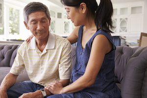 Adult Daughter Talking To Depressed Father At Home