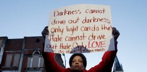 Carter of Tuscaloosa holds a sign as she waits on a commemorative march by the cast of the movie "Selma" in Selma, Alabama