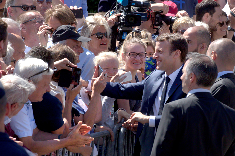 French President Emmanuel Macron greets supporters after having voted in parliamentary elections in Le Touquet