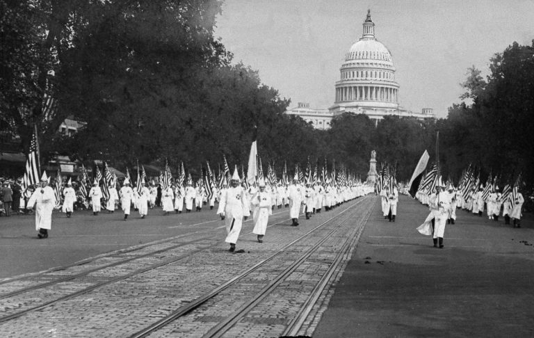 Ku Klux Klan members march in a parade along Pennsylvania Av