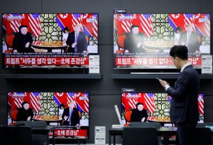 An employee watches a set of TV's broadcasting a news report on a Hanoi summit between North Korean leader Kim Jong Un and U.S. President Donald Trump, in Seoul