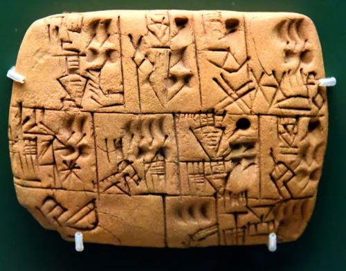 A clay tablet impressed with five different types of numerical symbol from Mesopotamia