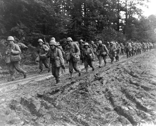 The 442nd Regimental Combat Team hiking up a muddy road in the Chambois Sector, France, in late 1944