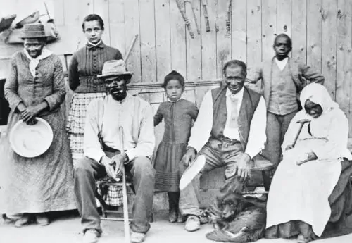 Harriet Tubman, far left, poses with her family, friends and neighbors near her barn in Auburn, N.Y.