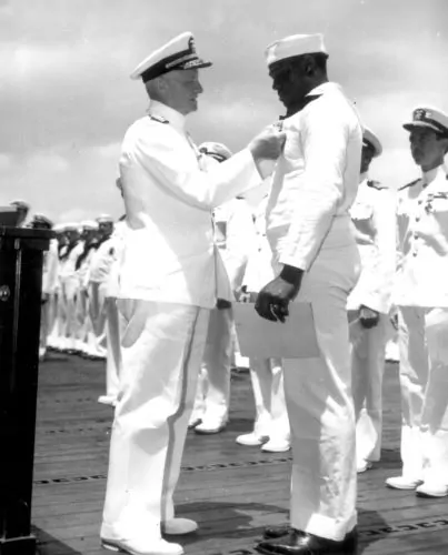 Admiral Chester W. Nimitz pins Navy Cross on Doris Miller, at ceremony on board warship in Pearl Harbor, May 27, 1942