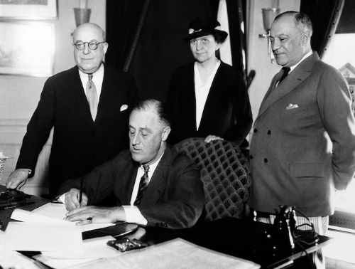 President Franklin D. Roosevelt signs the Wagner Unemployment Bill at the White House in Washington on June 6, 1933.