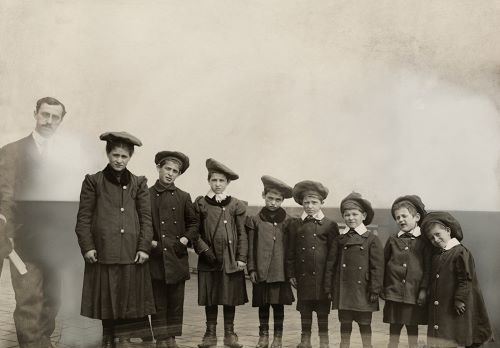 A man stands next to orphaned Russian Jews upon immigration to the United States, New York, July 1919