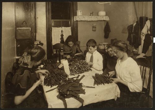 Jewish family working on garters in kitchen for tenement home, 1912