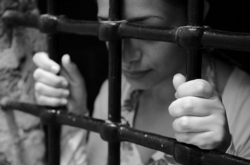A woman in prison behind bars