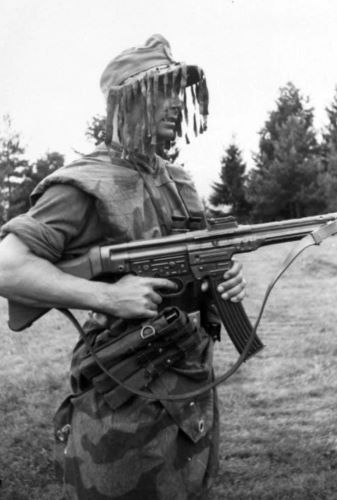 From Bolt to Burst: The StG 44 and the Shifting Geometry of Modern War 14 A German infantryman armed with an StG 44, wearing "splinter" camouflage and a ghillie cap in July 1944