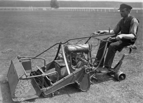 Man on a lawn mower in the 1930s.