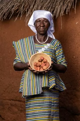 A woman holding a bowl of kola nuts