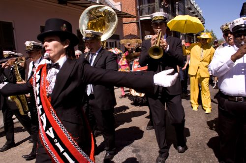 Local jazz singer Jane Harvey Brown leads the way as grand marshal for a brass band at a second line in the French Quarter in New Orleans