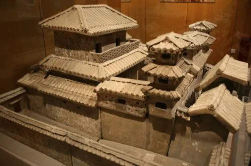 This pottery model of a palace found in a Han dynasty tomb displays outer walls and courts, gate houses, towers, halls, verandas, and roof tiles