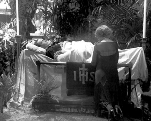 A fan named Eva Miller kneels at Valentino's coffin
